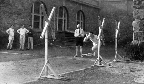 Арчибалд Хилл (в рубашке с галстуком и шортах) изучает стартовый разгон спортсмена