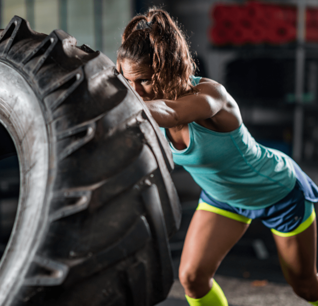 Девушка опрокидывает шину от трактора